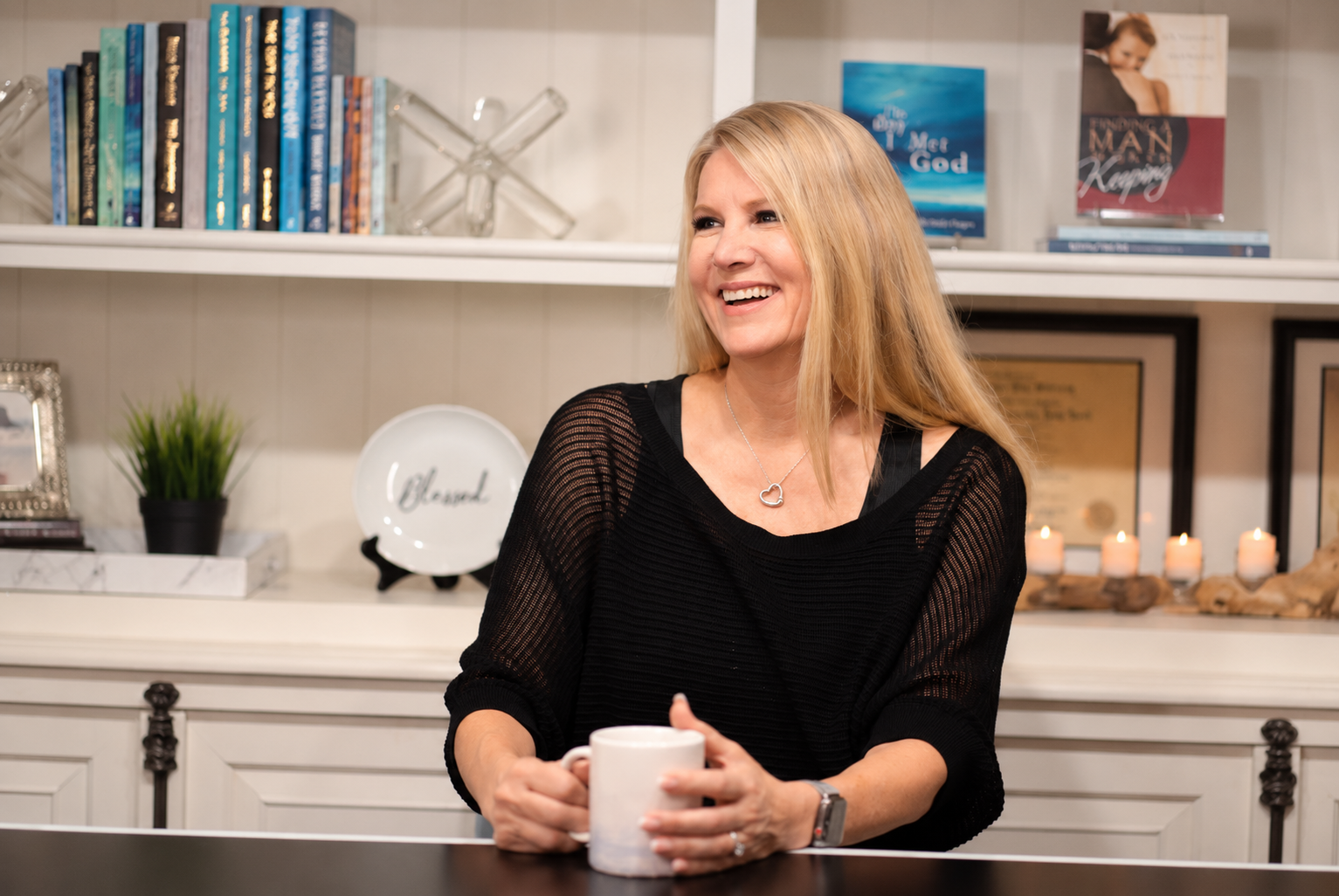 Dr. Victorya Rogers, Christian nonfiction author, holding a coffee cup in front of her books